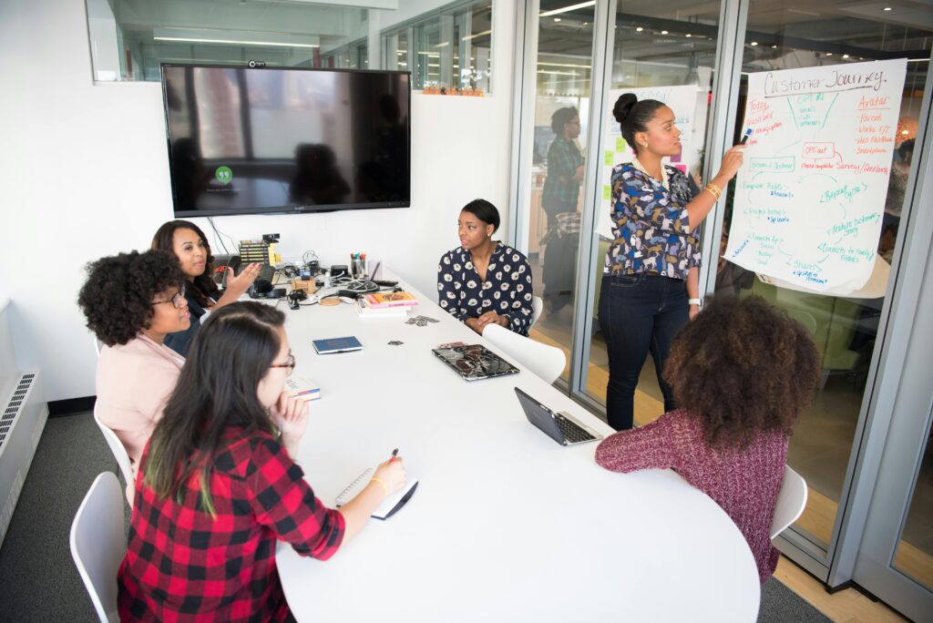 About A multicultural office team engages in a collaborative brainstorming session around a conference table.